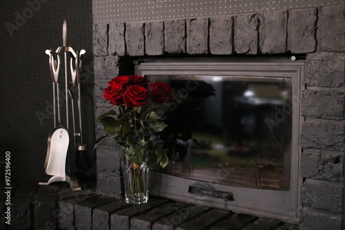 dark interior with red roses in a vase near a stone