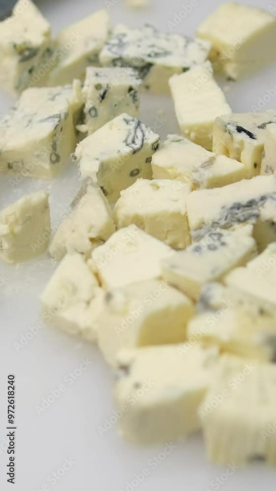 blue cheese Danish blue cheese. Close-up of female hand separating cubes of mycella cheese on a wooden cutting board. 4K video blue cheese Danish blue cheese. Close-up of female hand separating cubes of mycella cheese on a wooden cutting board. 4K video