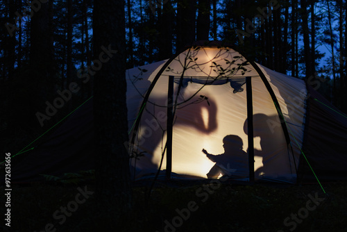 Fotografie Children making shadow puppets in a camping tent