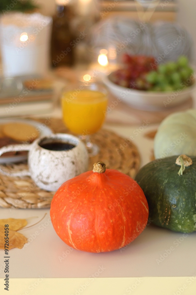 Pumpkins, various food and drinks, fall decorations, books and candles on the table. Fall hygge at home. Selective focus. Pumpkins, various food and drinks, fall decorations, books and candles on the table. Fall hygge at home. Selective focus.