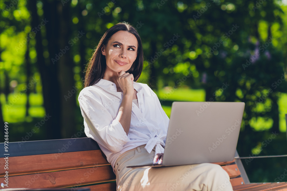 Photo of attractive young cheerful girl sit bench work netbook minded wear white garment having fun outside outdoors Photo of attractive young cheerful girl sit bench work netbook minded wear white garment having fun outside outdoors