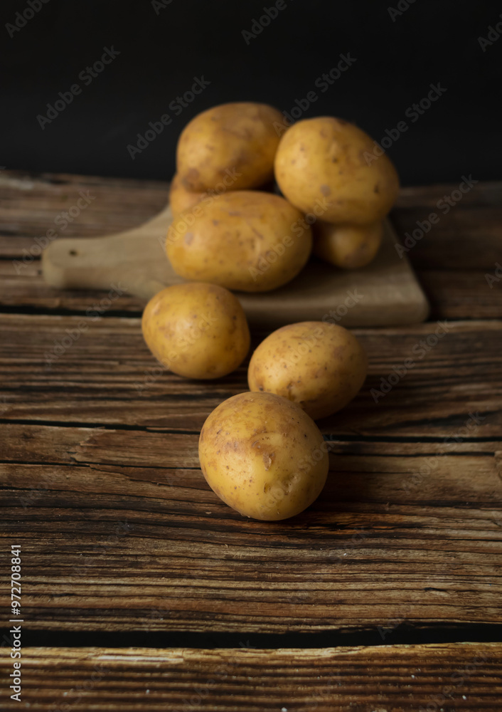 young raw potato. on a dark wooden background. food young raw potato. on a dark wooden background. food