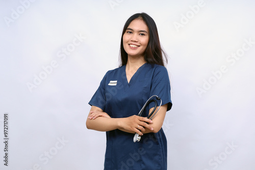 A female nurse is standing wearing scrubs and a stethoscope. He is smiling and looking camera.Portrait of young female nurse isolated on white