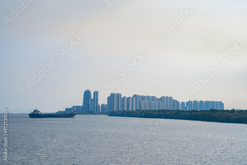 Tuas Second Link Bridge connecting Singapore and Johor, Malaysia. Buildings at Forest City and Singapore's port. View from the Straits of Johor.