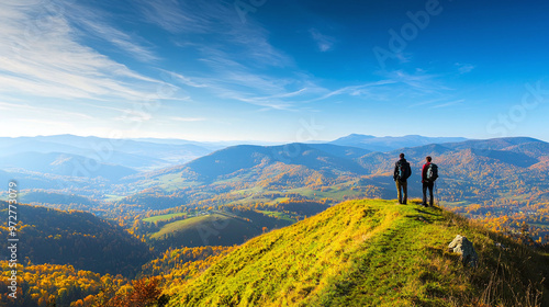 two hikers standing on a hilltop in autumn, admiring the breathtaking view of the colorful valley below