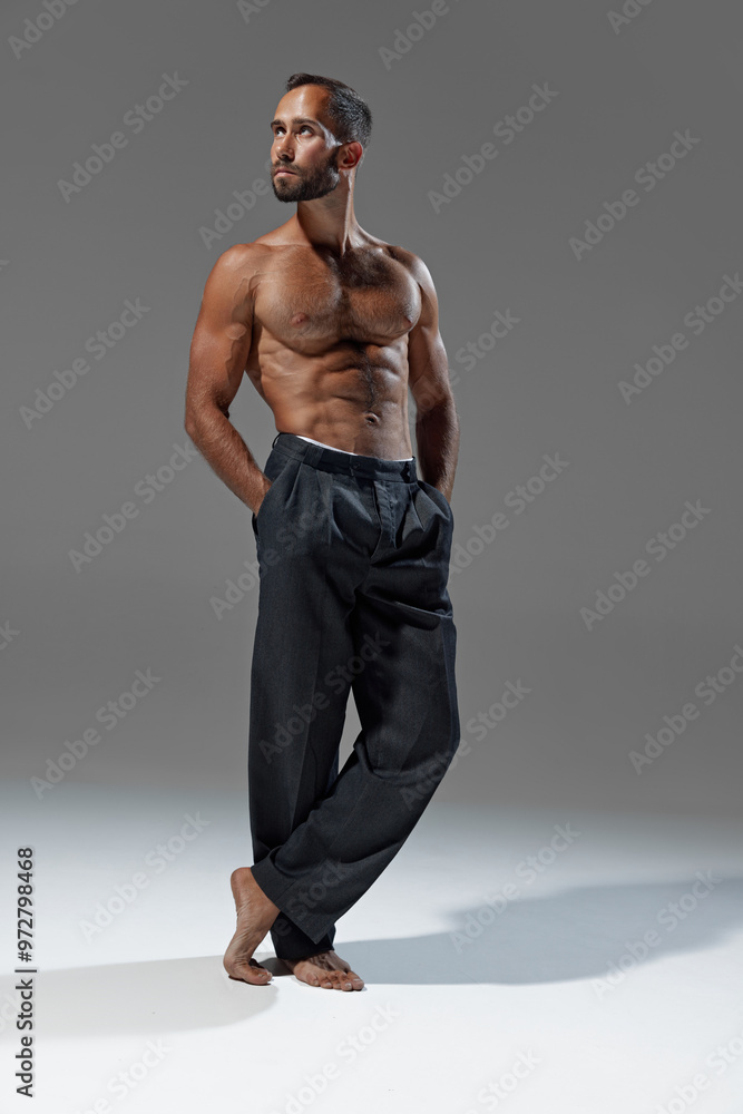 Classic pose. Standing tall with hands in his pockets, man displays blend of confidence, strength, and casual elegance. Concept of beauty and fashion, style and youth, male health. Classic pose. Standing tall with hands in his pockets, man displays blend of confidence, strength, and casual elegance. Concept of beauty and fashion, style and youth, male health.