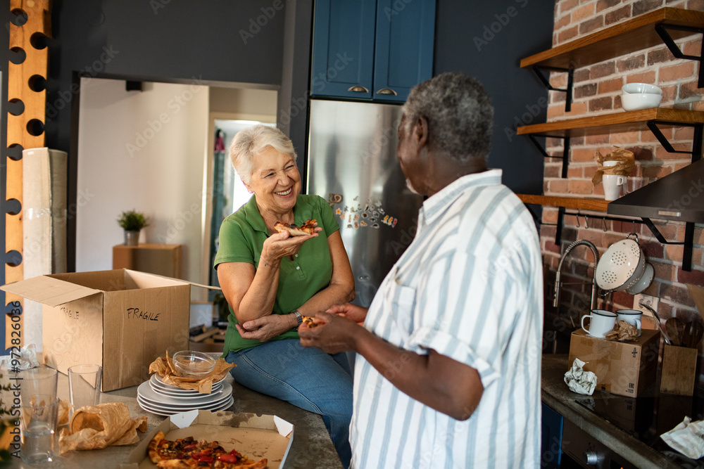 Senior couple eating pizza after moving into new home Senior couple eating pizza after moving into new home