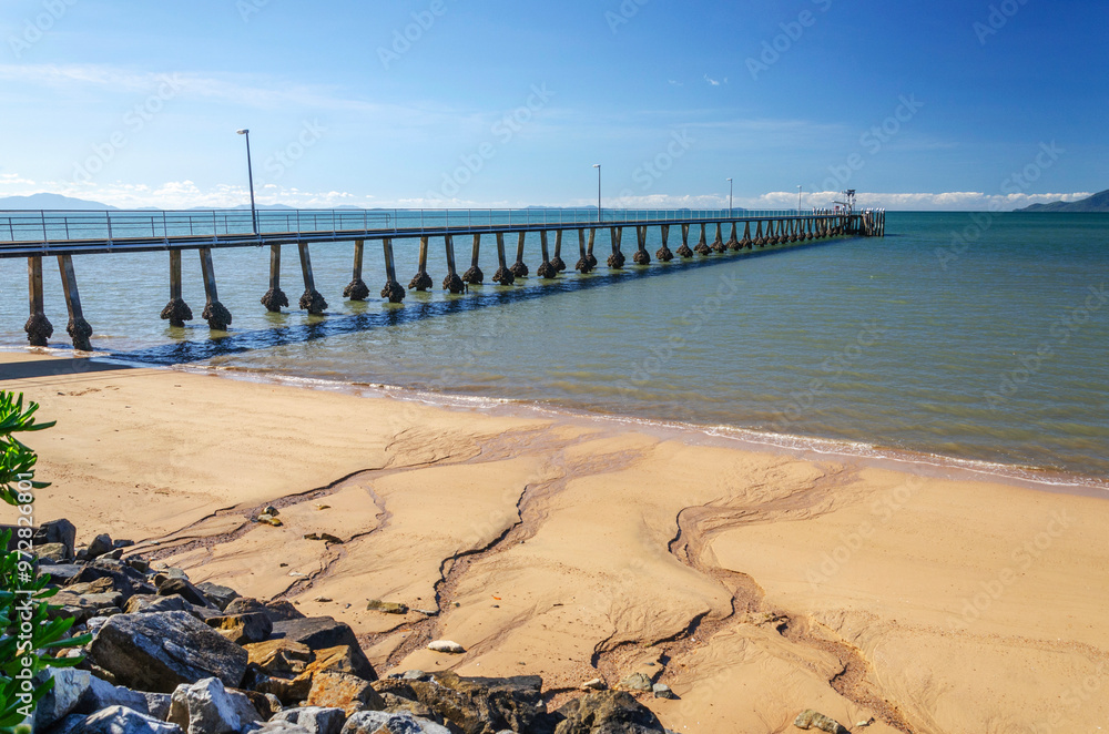 Fototapeta premium Pier and golden beach in Cardwell town in Queensland, Australia. Cardwell is coastal town and rural locality in Cassowary Coast Region.