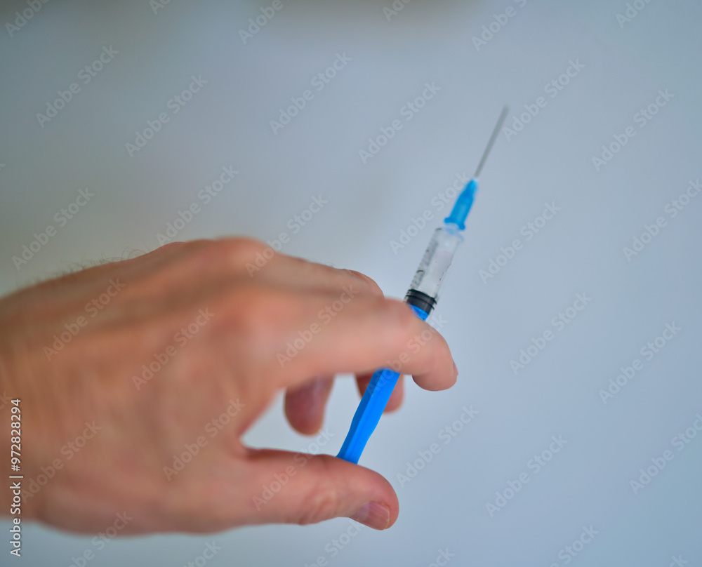 a fragment of a human hand holds a syringe a fragment of a human hand holds a syringe