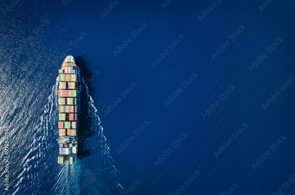 High aerial top view of a commercial container cargo ship in motion with copy space as a concept for transport and industry
