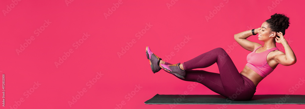 Double crunch excercise. Black sporty girl working out over red studio background, panorama with free space Double crunch excercise. Black sporty girl working out over red studio background, panorama with free space