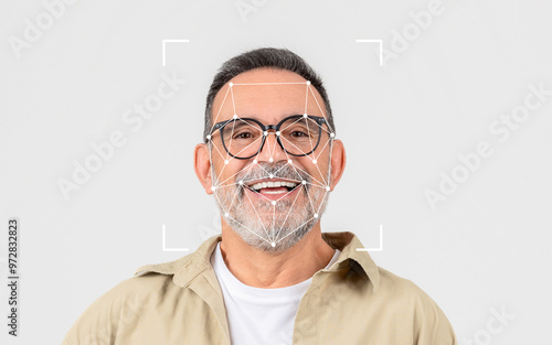 A smiling older man wears glasses, with a facial recognition grid overlay, set against a simple light background. photo