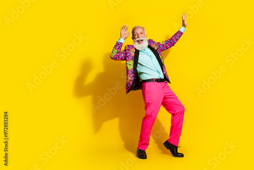 Full size photo of extravagant elderly man classy vibrant clothes dance empty space isolated on yellow color background