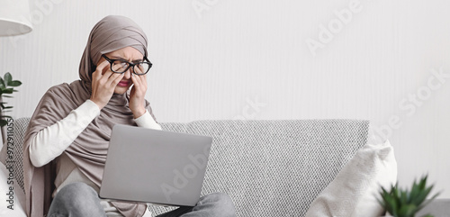 Eye Strain. Tired Muslim Woman In Hijab Having Eyesight Problem, Massaging Nosebridge After Working On Laptop At Home, Free Space photo