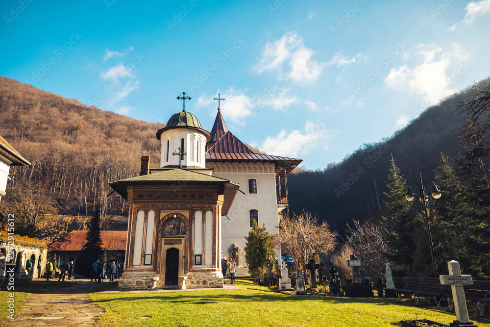 A tranquil winter day unfolds at a historic monastery, where the captivating architecture blends harmoniously with the surrounding lush valley landscape and mountains in the distance A tranquil winter day unfolds at a historic monastery, where the captivating architecture blends harmoniously with the surrounding lush valley landscape and mountains in the distance