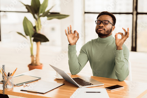 Relaxation At Work. Afro businessman meditating at work, dealing with stress and anxiety. Free space