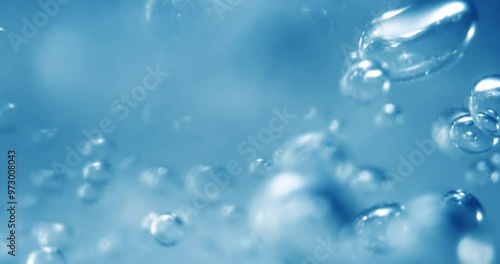Many water bubbles in blue water close up, abstract water wave with bubbles in slow motion.