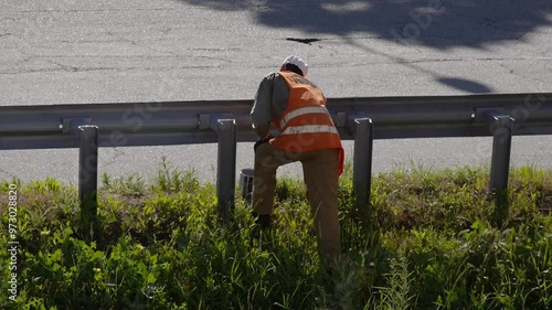 Service Worker Painting A Road Barrier On The Street
