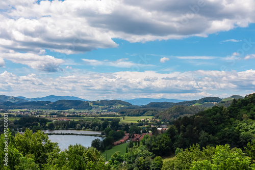 Panoramic view of small lake and rolling hills with vineyards in Leibnitz, south west Styria, Austria, Europe. Idyllic landscape along wine street. Small villages nestled in remote nature retreat area photo