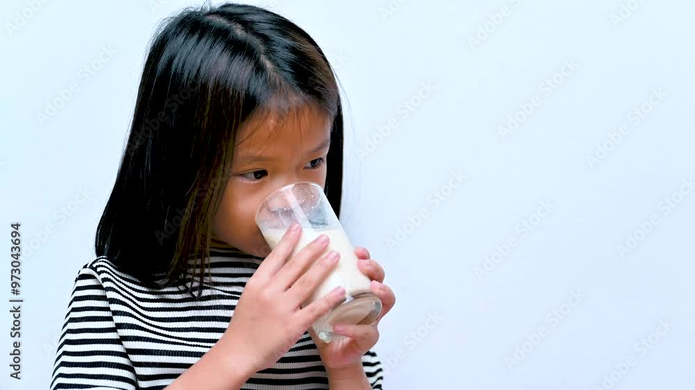 Smiling girl drinking Plant-based milk from a glass, Tastes so good. Smiling girl drinking Plant-based milk from a glass, Tastes so good.