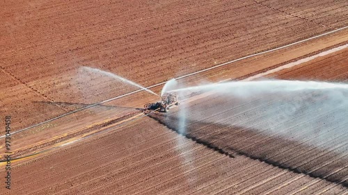 farm irrigator watering ploughed red dirt paddock field, farming agriculture agricultural equipment, water use conservation environment
