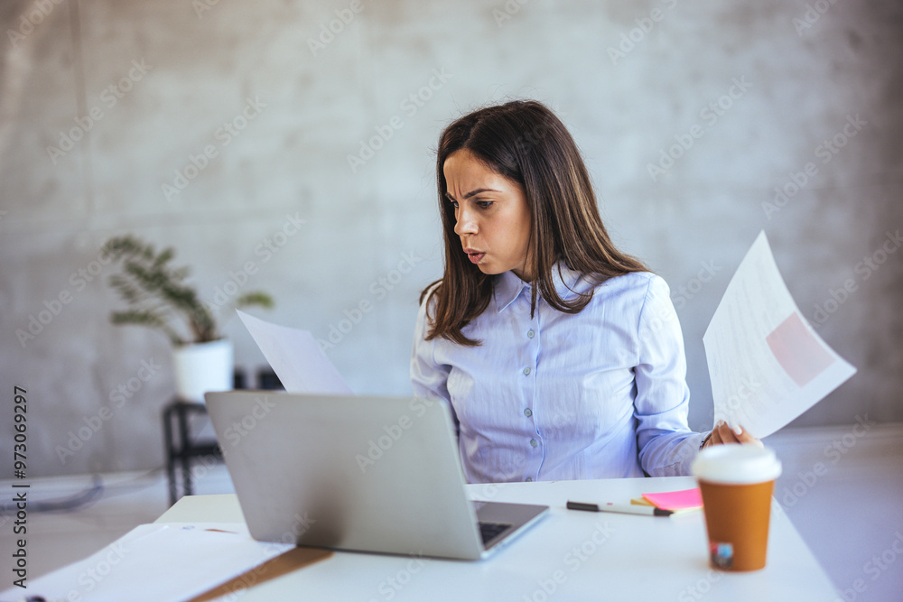 Frustrated Businesswoman Reviewing Documents at Office Desk Frustrated Businesswoman Reviewing Documents at Office Desk