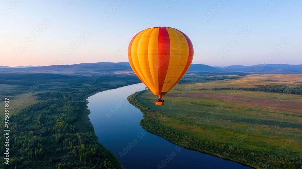 Obraz premium A single hot air balloon rising above a winding river, clear sky reflecting on the water s surface, Calm, soft light, serene