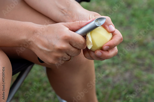 Women's hands peel potatoes with a knife, close-up