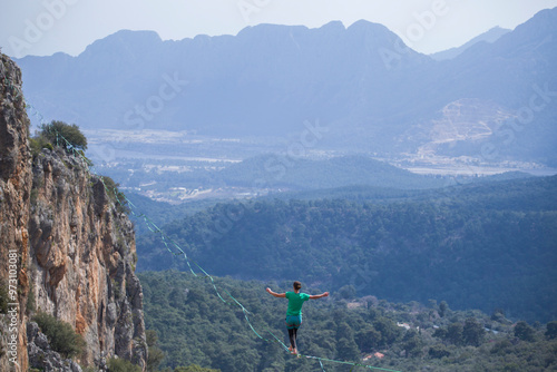 A tightrope walker walks along a cable stretched over a canyon. photo