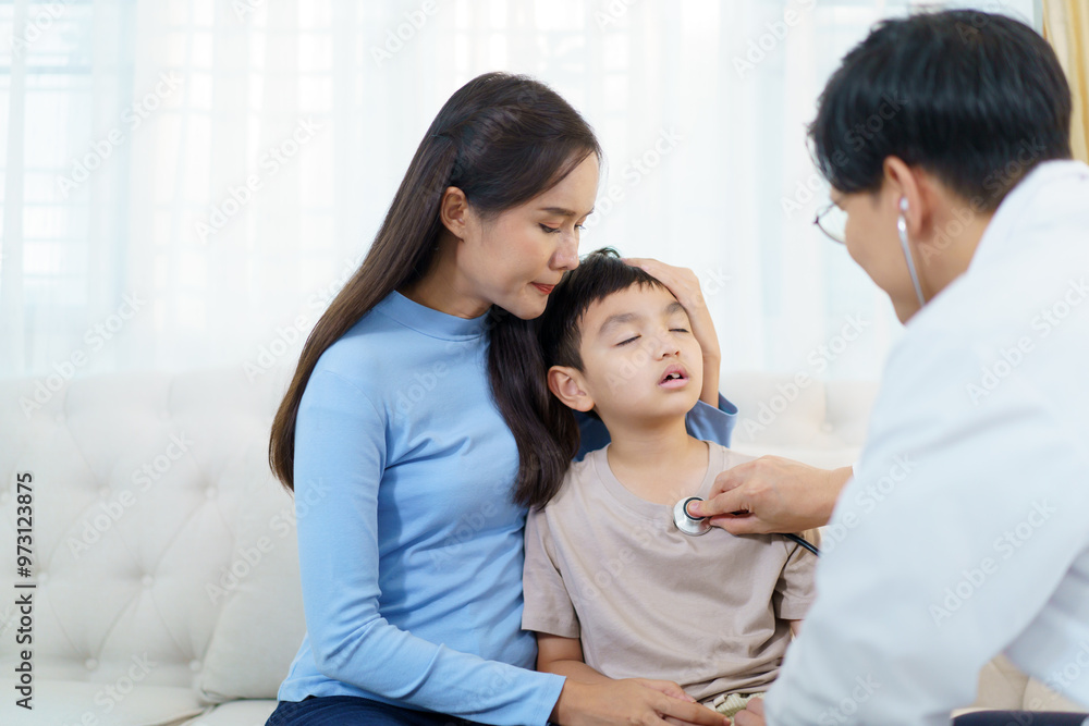 An Asian woman taking her sick little son to see doctor in the hospital, then doctor is examining the boy's respiratory system. An Asian woman taking her sick little son to see doctor in the hospital, then doctor is examining the boy's respiratory system.