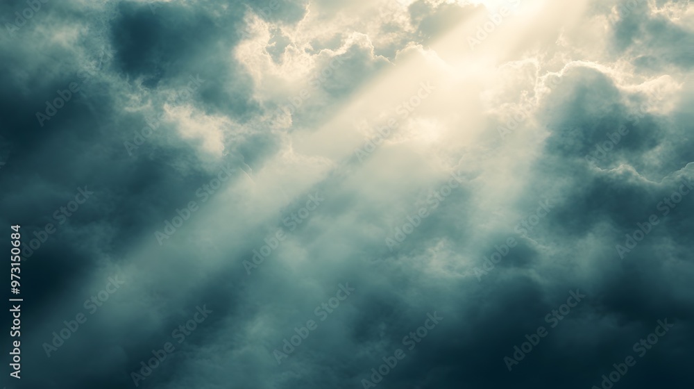 Obraz premium Dramatic Sunbeams Shining Through Moody Clouds in Majestic Heavenly Landscape