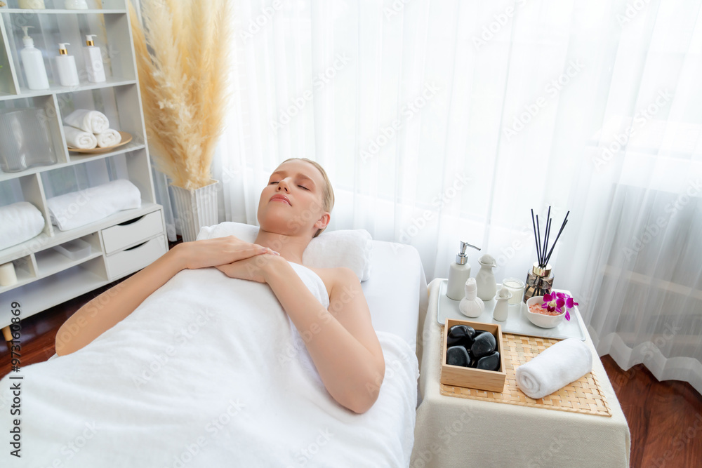 Caucasian woman customer enjoying relaxing anti-stress spa massage and pampering with beauty skin recreation leisure in day light ambient salon spa at luxury resort or hotel. Quiescent Caucasian woman customer enjoying relaxing anti-stress spa massage and pampering with beauty skin recreation leisure in day light ambient salon spa at luxury resort or hotel. Quiescent