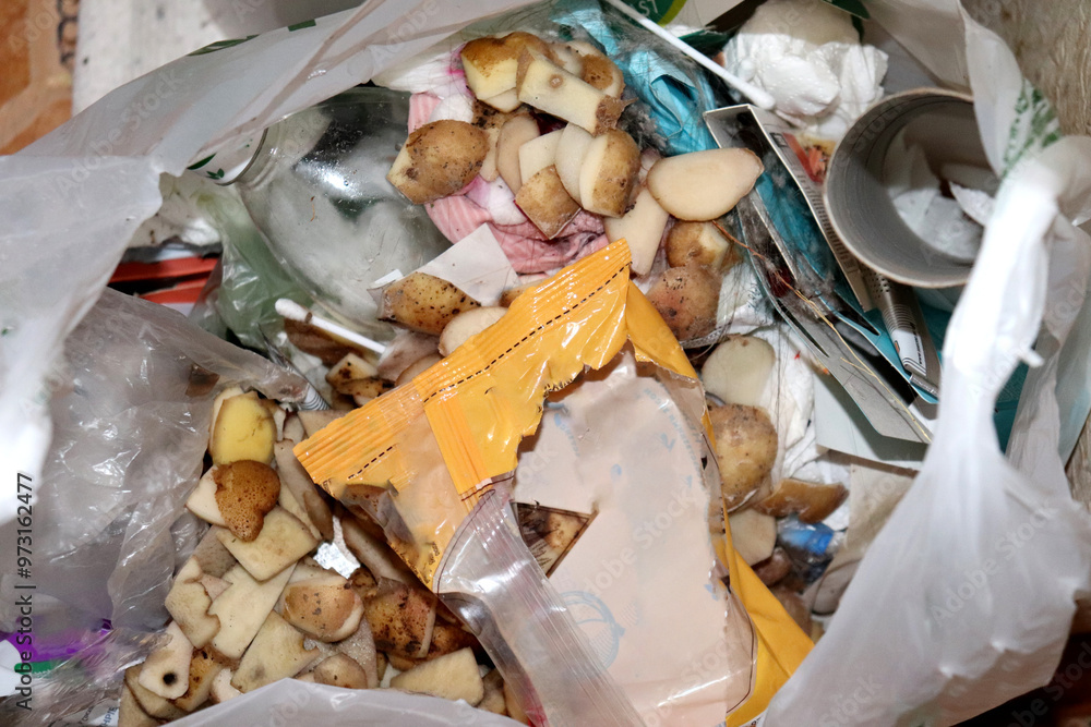 Plastic bag with food and household unsorted waste - horizontal photo, close-up. Potato peels, wrappers, bottles, paper, bags Plastic bag with food and household unsorted waste - horizontal photo, close-up. Potato peels, wrappers, bottles, paper, bags