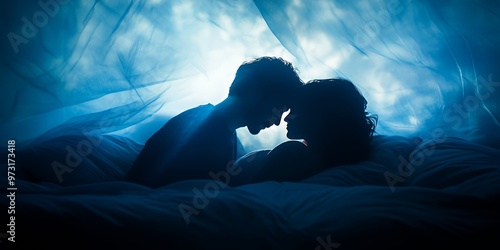 Silhouetted couple in bed with blue sheets under a sheer fabric canopy.