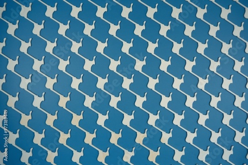 Blue and white pattern. Abstract background with repeated pattern of white shapes on blue surface.