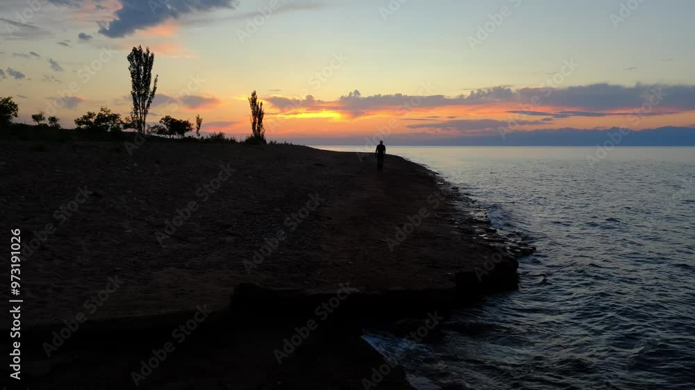A Peaceful and Tranquil Sunset Over the Water, Featuring a Stunning Silhouette A Peaceful and Tranquil Sunset Over the Water, Featuring a Stunning Silhouette