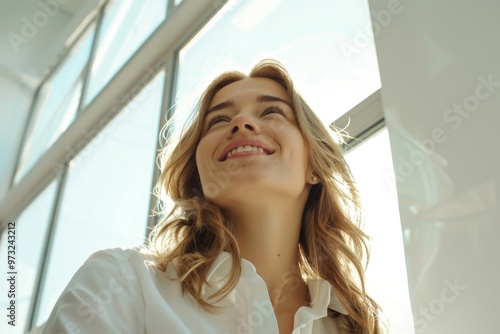 Free Download A woman wearing a white shirt smiles upwards, possibly feeling happy or uplifted - GFXLoad