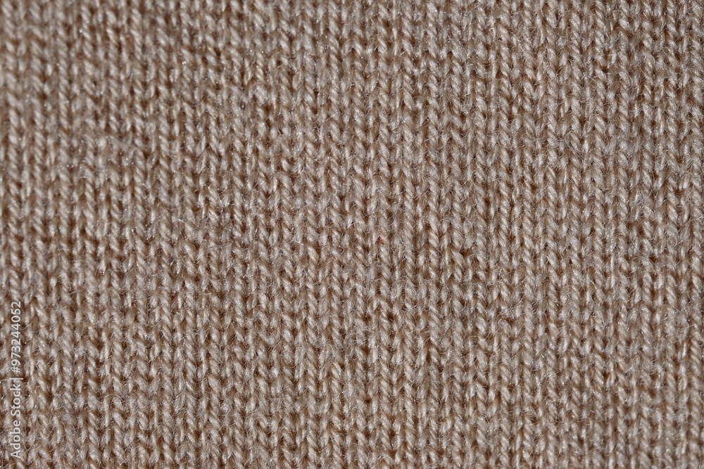 brown texture of knitted wool fabric as a background, smooth symmetrical lines of hand-knitted needlework pattern brown texture of knitted wool fabric as a background, smooth symmetrical lines of hand-knitted needlework pattern