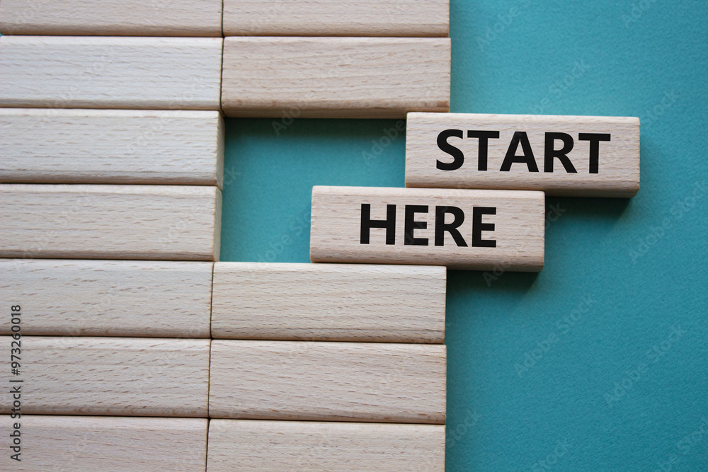 Start here symbol. Wooden blocks with words Start here Beautiful grey green background. Business and Start here concept. Copy space. Start here symbol. Wooden blocks with words Start here Beautiful grey green background. Business and Start here concept. Copy space.
