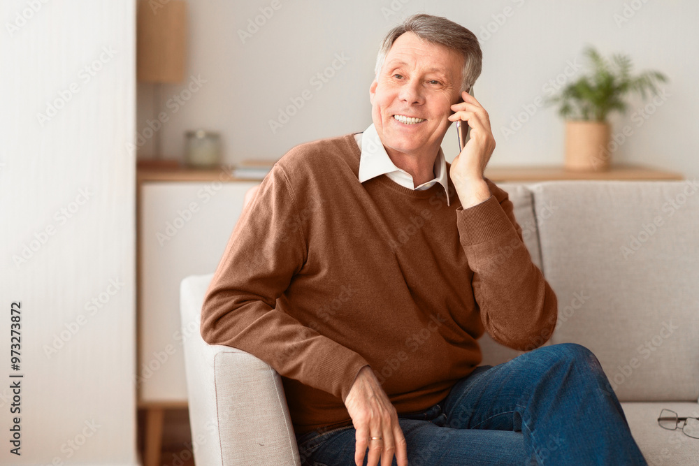 Phone Call. Cheerful Old Man Talking On Cellphone Sitting On Sofa At Home. Free Space Phone Call. Cheerful Old Man Talking On Cellphone Sitting On Sofa At Home. Free Space