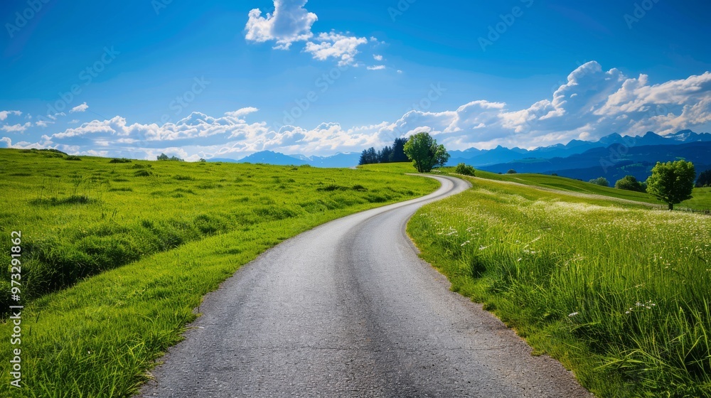 Naklejka premium Road cutting through Alpine meadows, blue sky, summer vibes, Close-up photo with clean background