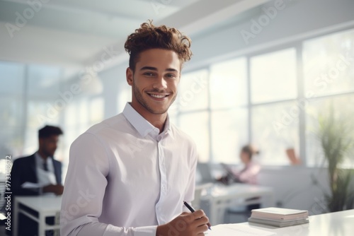 A smartly dressed man with a bright smile stands poised in an elegant, well-lit office, radiating confidence and professionalism. photo