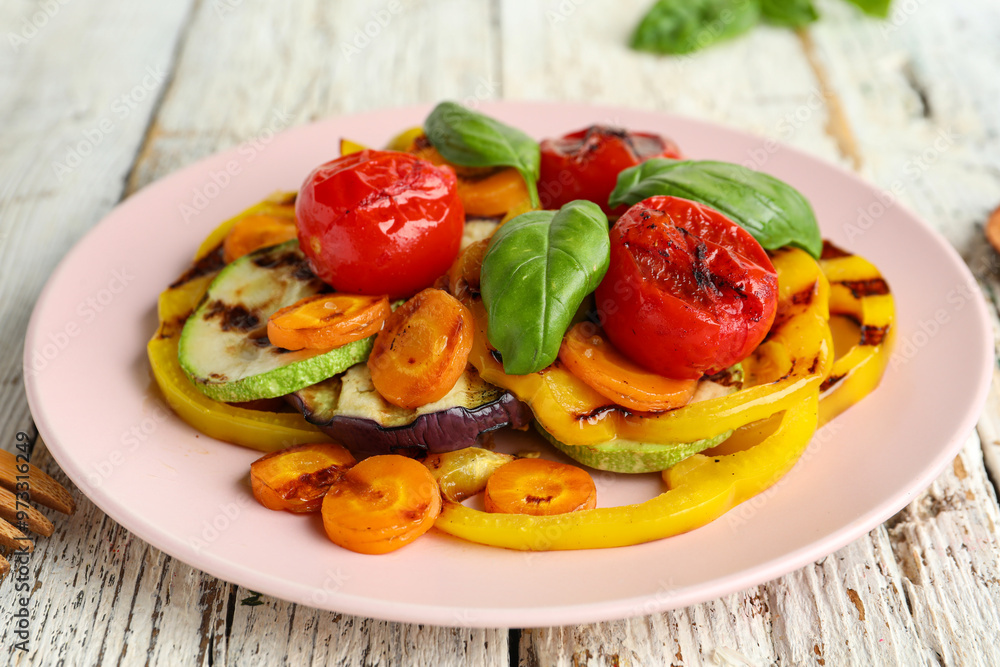 Plate with grilled vegetables and basil on white wooden table Plate with grilled vegetables and basil on white wooden table
