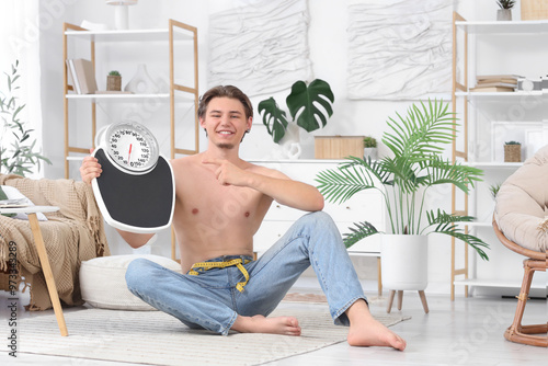 Young man with scales sitti...