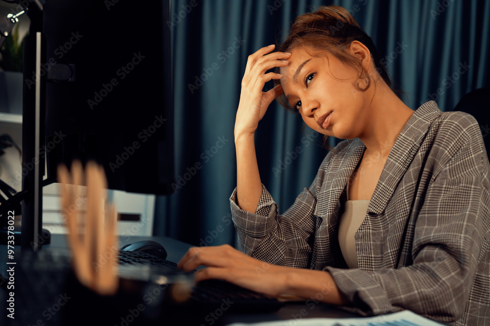 Businesswoman working on computer with stretching arm up and down manner with body health ache of strain overwork unfinished project job on website at late over night time at modern office. Infobahn. Businesswoman working on computer with stretching arm up and down manner with body health ache of strain overwork unfinished project job on website at late over night time at modern office. Infobahn.