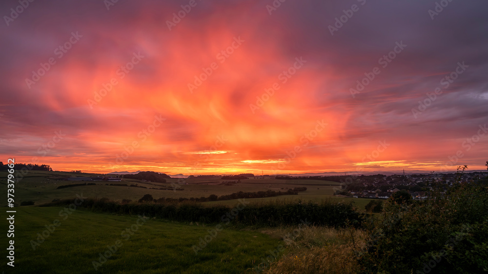 Dramatic sunset across farm fields with Goat Fell Isle of Arran on horizon Dramatic sunset across farm fields with Goat Fell Isle of Arran on horizon