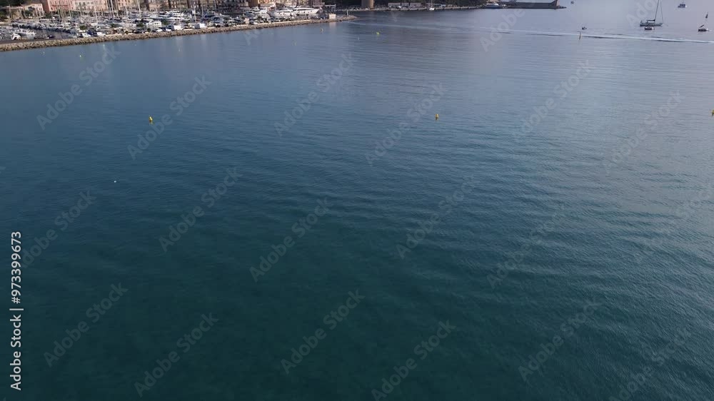 Blick nach oben vom blauen Meer auf die historische Stadt Calvi, Korsika