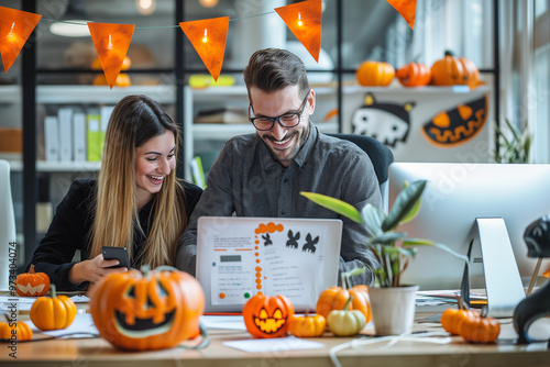 Two colleagues working together at a desk decorated for Halloween. Concept of collaboration and festive office culture.