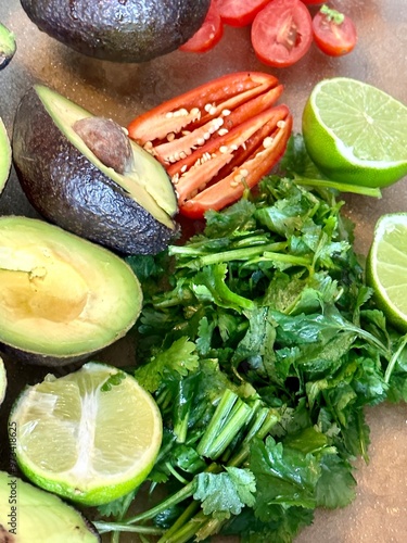 ingredient vegables in vibrant colors for a mexican guacamole dish ready on a cutting board photo