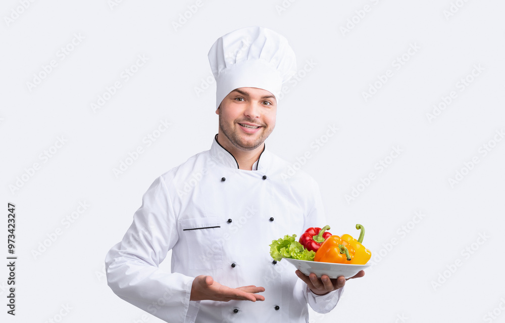 Chef Man Holding Plate With Vegetables Standing Over White Background. Salad Recipes. Studio Shot, Panorama Chef Man Holding Plate With Vegetables Standing Over White Background. Salad Recipes. Studio Shot, Panorama